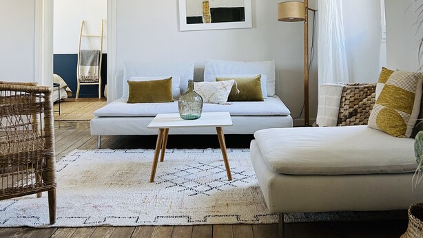 A living room with a white sofa, a coffee table, a wicker chair, and a wooden floor. - Maison vue Mer , Proche Bastia (Bastia)