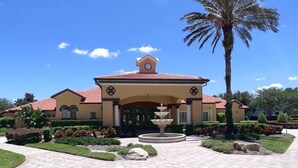 A building with a central fountain, palm trees, and a clear blue sky. - Spacious Family Pool Home with Game Room (Davenport)