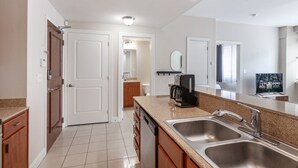 Una cocina moderna con un lavamanos doble, una cafetera y un refrigerador.