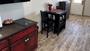 Une cuisine compacte équipée d’un four à micro-ondes, d’une cuisinière et d’un coin repas avec une table et des chaises.