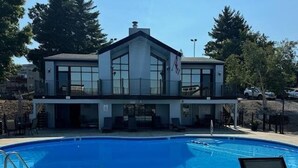 A building with a swimming pool, a flag, and a chair. - Bridgepointe Condo 432 (Osage Beach)