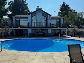 Un bâtiment doté d’une piscine, d’un drapeau et d’une chaise.