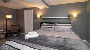 Ein Hotelzimmer mit einem großen Bett, zwei Wandlampen, einem Sessel und einem kleinen Tisch.