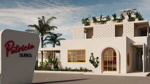 Een modern gebouw met een bord waarop 'Patricia Suites' staat.