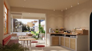 Een moderne keuken met een koffieapparaat, een fruitmand en een ontbijtbalk.