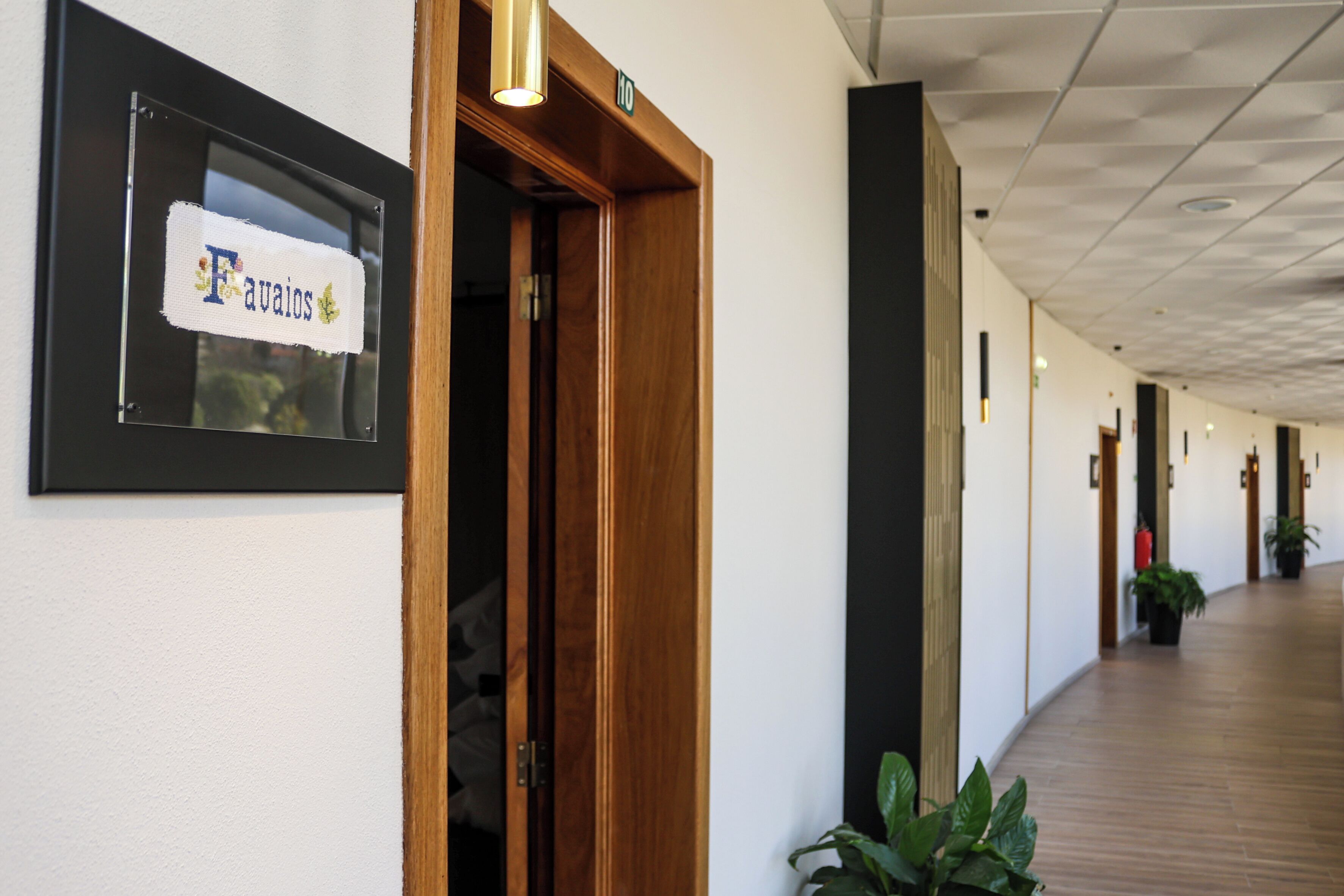 Un pasillo con una puerta de madera que dice "Favaios" y un letrero con el número "10".