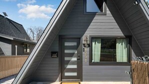 A modern house with a sloped roof, a welcome mat, and a mailbox.