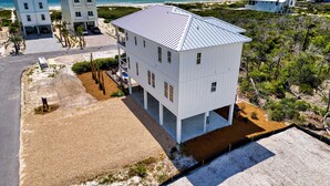 A multi-story white building with a flat roof, located near a beach with a clear view of the ocean. - The Sand Pearl-New/N Cape/Steps to Beach/5 BR (Port St. Joe)