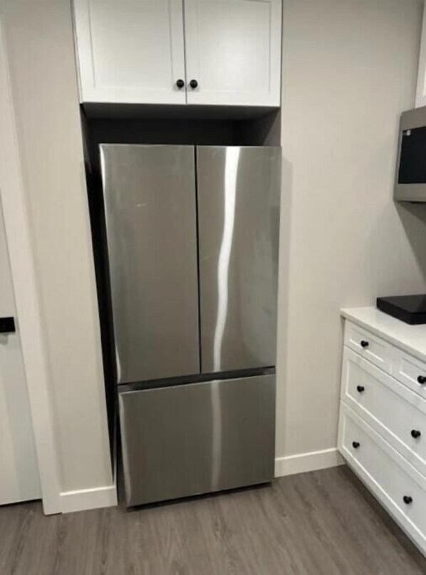 A stainless steel refrigerator in a kitchen with white cabinets and a white countertop. - Home Away From Home:Brand new,Quite, cozy two bed rooms separate accommodation (Winnipeg)
