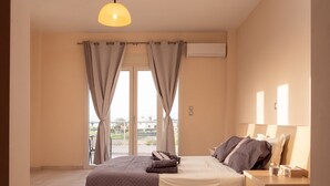 Une chambre à coucher avec un lit, une table de chevet, une lampe et une vue sur l’extérieur.