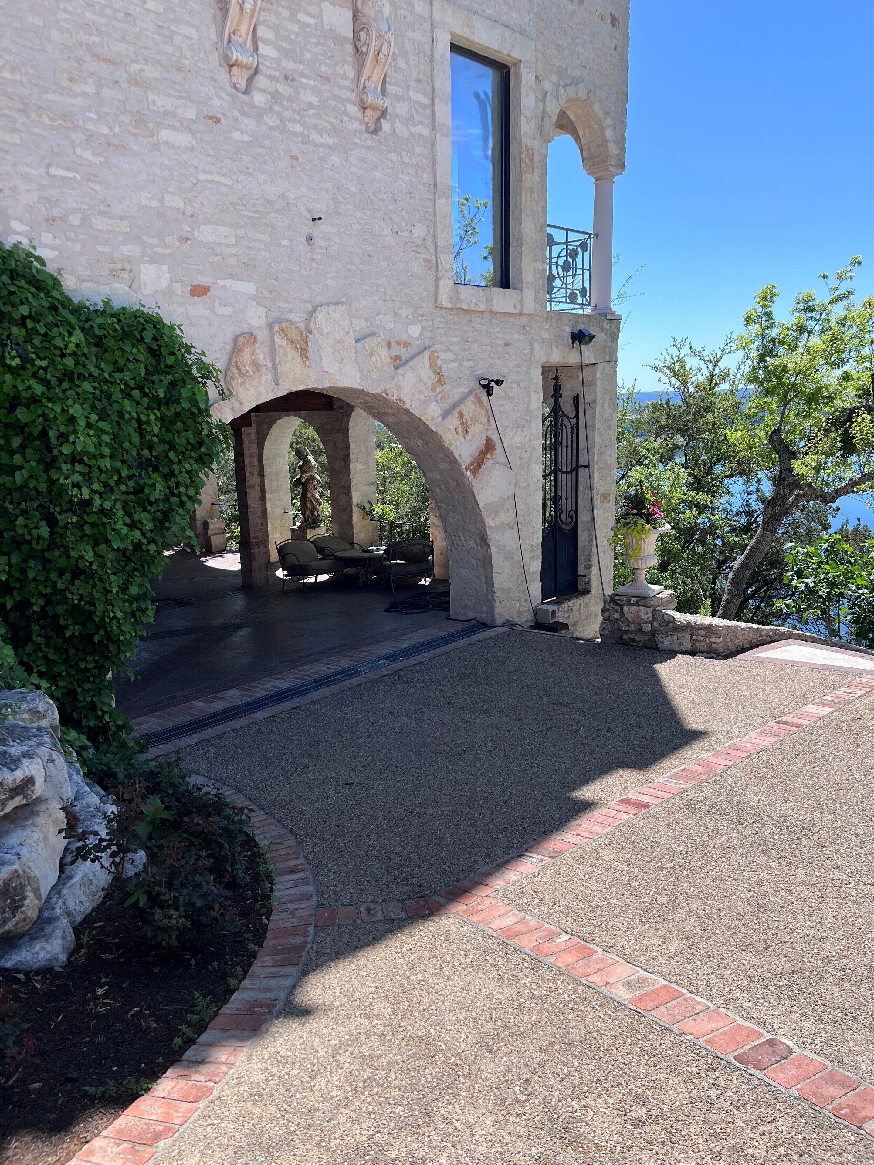 Un bâtiment en pierre doté d’une entrée couverte, de places assises en plein air et d’une vue sur la mer.