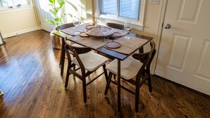 Un coin repas avec une table en bois, quatre chaises et une plante en pot.