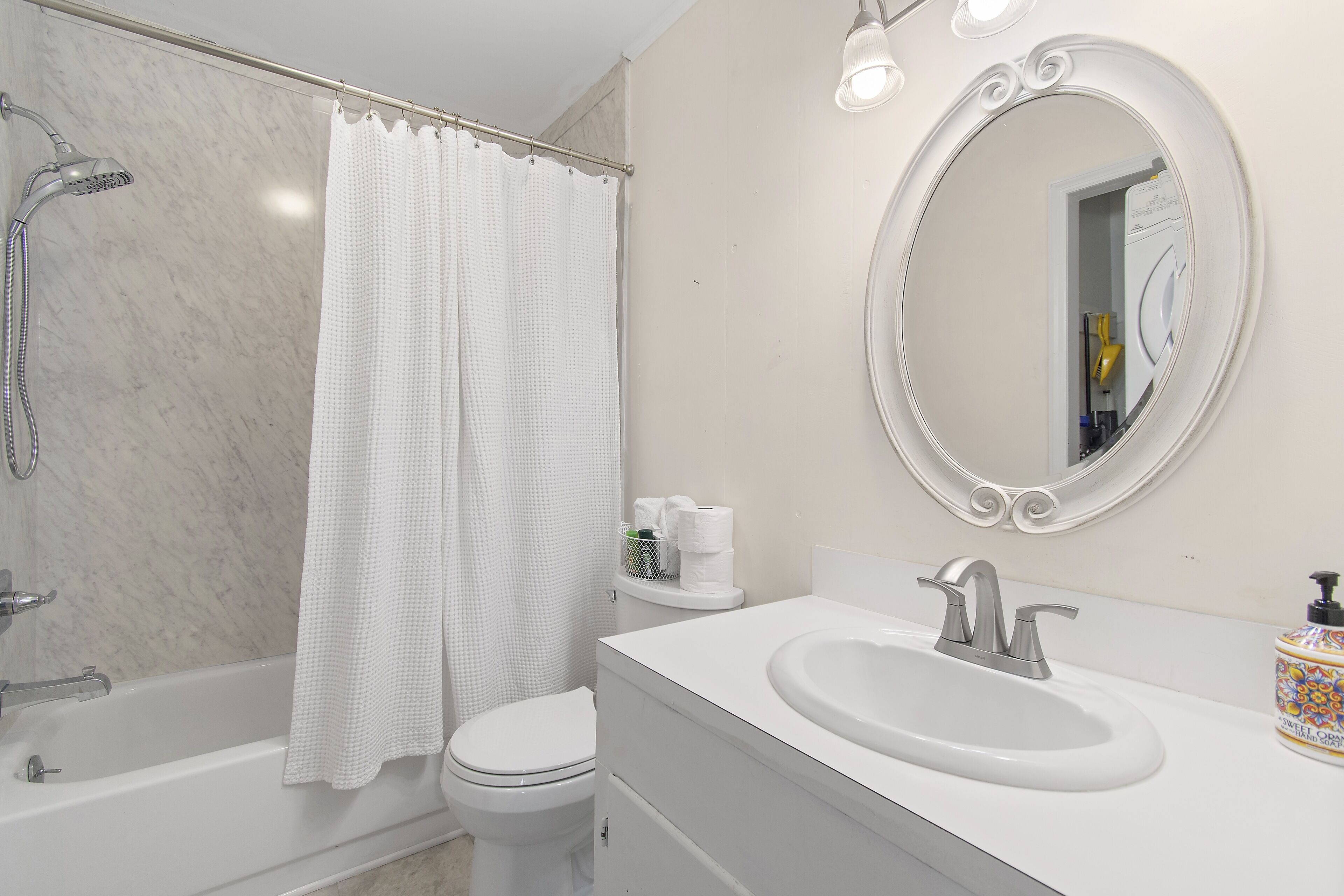 A bathroom with a bathtub, toilet, and sink.