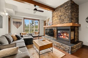 Una sala de estar con chimenea de piedra, un sofá y una mesa de centro.