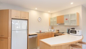 Una cocina moderna con armarios de madera, lavavajillas integrado, microondas y un lavabo.
