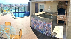 Enjoy a refreshing swim in the pool surrounded by a bar area and seating with city views.