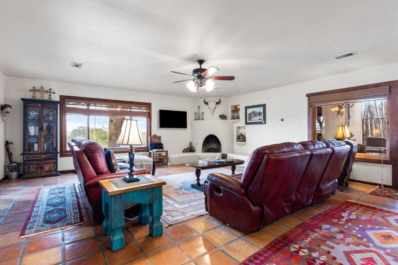 A living room with a fireplace, leather sofa, and a coffee table.