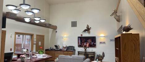 Ein großzügiger Wohnbereich mit Kamin, Fernseher und Essbereich mit Holztisch und Stühlen.