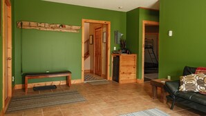 A green-walled living room with a wooden bench, a small table, and a sofa. - Welcome to Leech Lake Lodge! (Federal Dam)