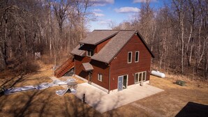 A two-story wooden cabin with a sloped roof, a covered porch, and a small attached shed. - Welcome to Leech Lake Lodge! (Federal Dam)