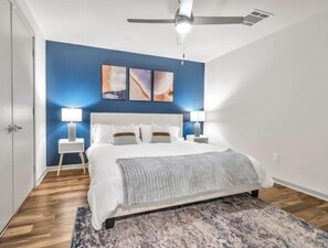 Relax in this stylish bedroom with a large bed, two bedside tables, and a patterned rug.