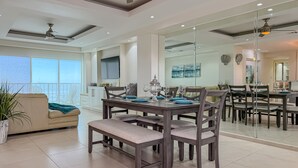 A modern dining area with a large table, chairs, and a ceiling fan. - Downtown Oceana Condo/2 Min Walk to Papas&Beer (Playas de Rosarito)