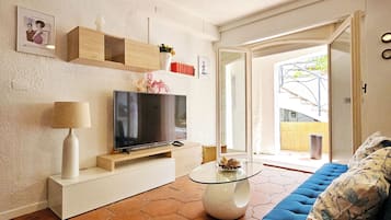 Departamento Deluxe, vista al patio | Área de sala de estar | Televisión de pantalla plana de 28 pulgadas con canales por cable