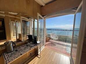 A balcony with a view of the sea, a coffee maker, and a chair. - VILLA RITA SEA FROT VIEW (Sanremo)