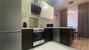A modern kitchen with a built-in oven, a microwave, and a dishwasher. - Apartment  Home Apart Minsk Zaharova 24 (Minsk)
