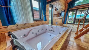 A wooden cabin with a large bathtub, wooden floors, and a balcony with a view of the sea. - AYVALIK TRİNGO BUNGALOV (Ayvalik)