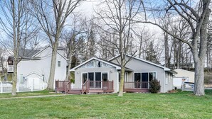 A single-story house with a front deck, a garage, and a small porch. - House on Paw Paw Lake w/ Private Dock! (Watervliet)