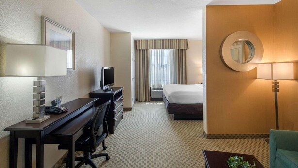 A hotel room with a desk, a bed, a TV, a mirror, and a window with curtains. - Fairfield Inn & Suites Hillsboro (Hillsboro)