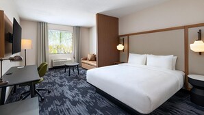 A hotel room with a large bed, a desk with a chair, a TV, and a window with curtains. - Fairfield Inn & Suites Hillsboro (Hillsboro)