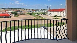 A balcony with a curved black metal railing overlooking a parking area and buildings in the distance. - Fairfield Inn & Suites Hillsboro (Hillsboro)
