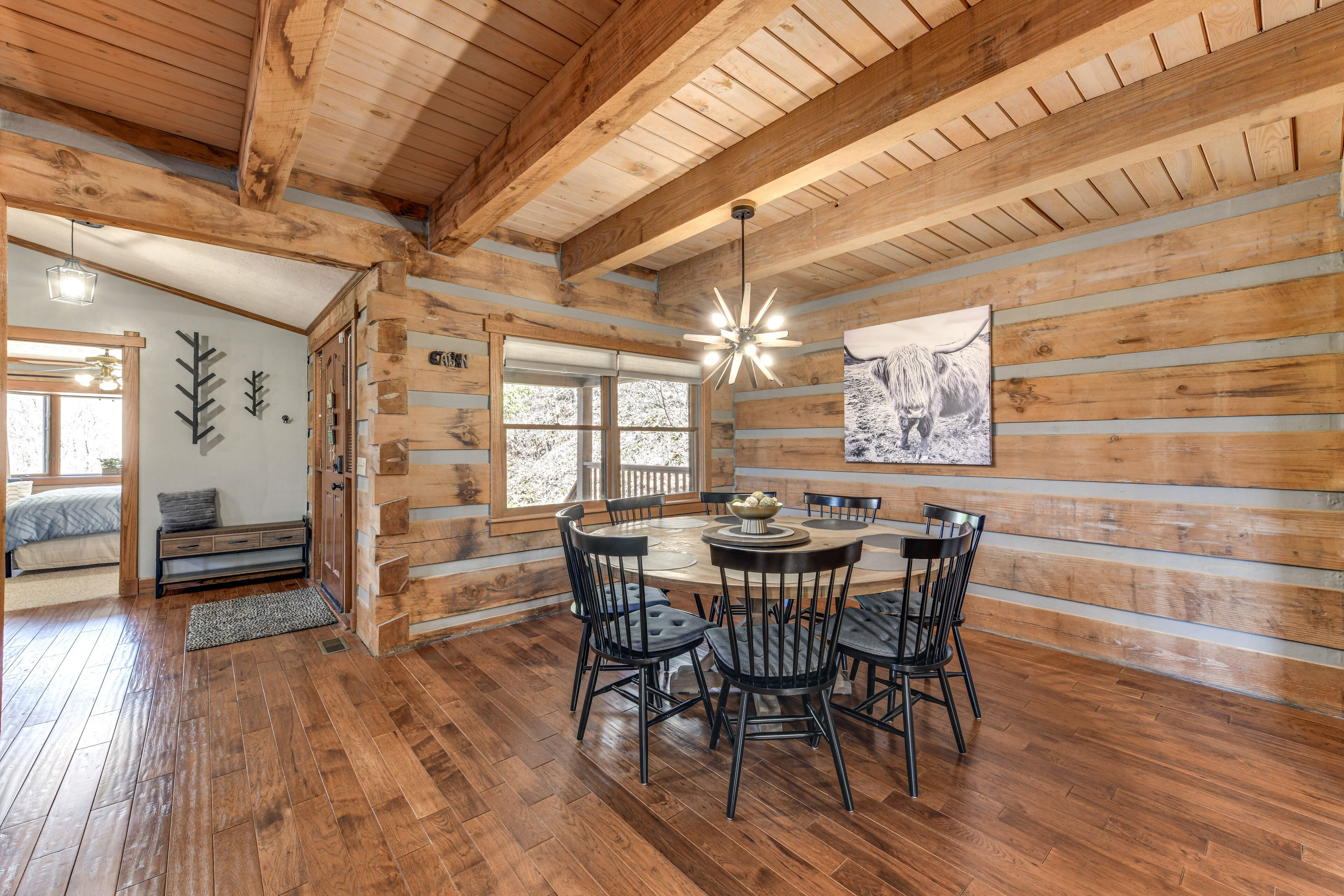 L’intérieur d’une cabane en bois comprend un coin repas, des murs en bois et un ventilateur de plafond.