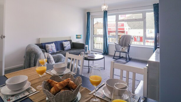 Un petit-déjeuner convivial, avec des croissants, du jus d’orange et une vue sur un théâtre visible à travers la fenêtre.