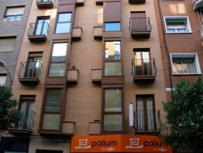 Um edifício com vários andares, varandas, janelas e uma placa com a inscrição 'palium'.
