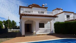 A two-story house with a swimming pool in the foreground. - Villa California (Salou)