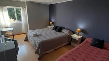 Una habitación con dos camas, un escritorio y una silla.