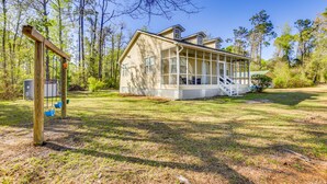 A house with a large porch, surrounded by trees and a grassy yard. - Lake Seminole Retreat w/ Private Dock (Bainbridge)