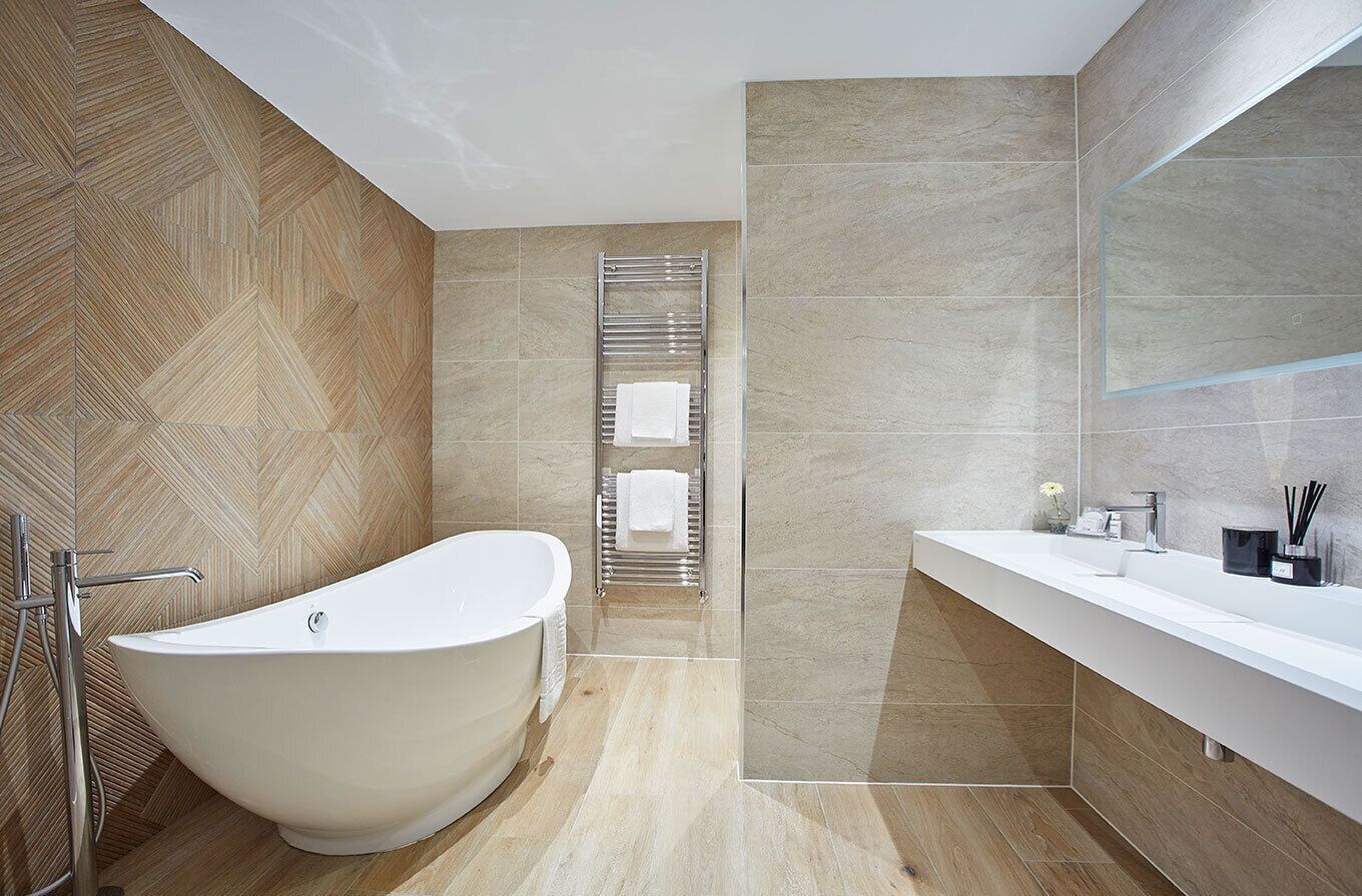 A modern bathroom with a freestanding bathtub, a glass-enclosed shower, and a vanity with a mirror.