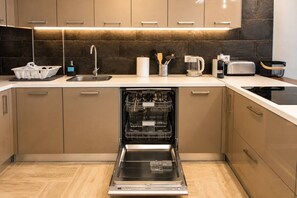 A modern kitchen with a dishwasher, a coffee maker, and a toaster.