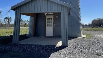 A small, single-story building with a metal silo attached to its side.