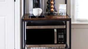 A kitchen area with a coffee maker, a mug rack, and a microwave on a black shelf. - Cozy 1 Bedroom Apartment (New Castle)