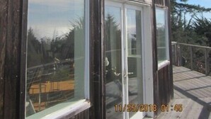 Un edificio in legno con ampie finestre e un patio.