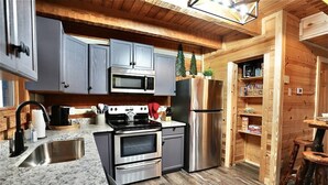 A kitchen with granite countertops, stainless steel appliances, and wooden cabinetry.