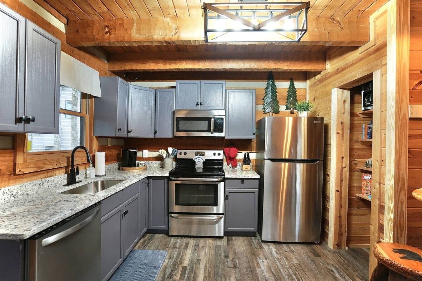 A modern kitchen with granite countertops, stainless steel appliances, and wooden cabinetry.