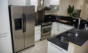 A modern kitchen with stainless steel appliances, a built-in oven, and a microwave.
