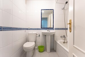 Bathroom features a pedestal sink, toilet, shower area with showerhead and handheld attachment, and a mirror.