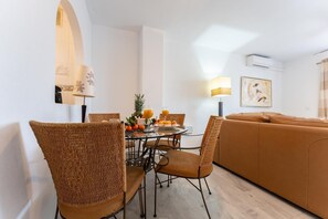 Relax in this stylish living room with a round dining table, comfortable sofa, and cozy seating area.
